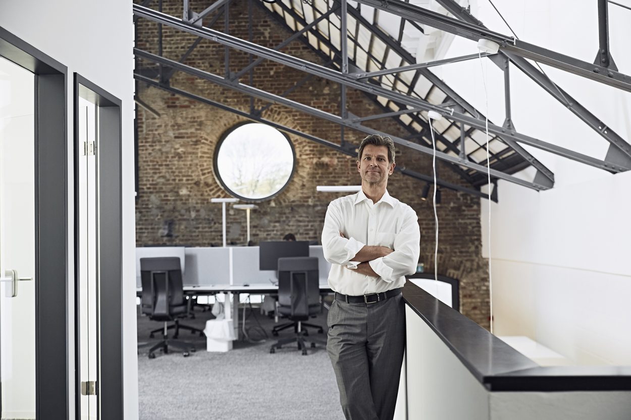 Businessman in modern office. Standing with arms folded : JCM Health & Safety Compliance in Liverpool & throughout the UK.